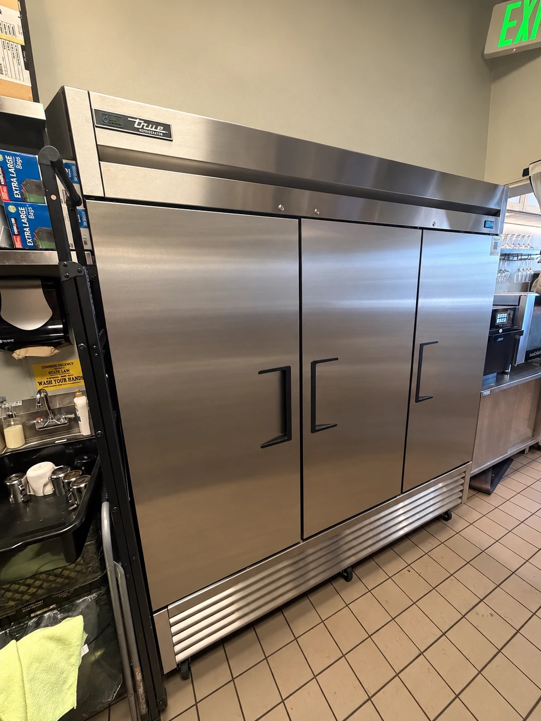 Commercial stainless steel refrigerator in a working kitchen